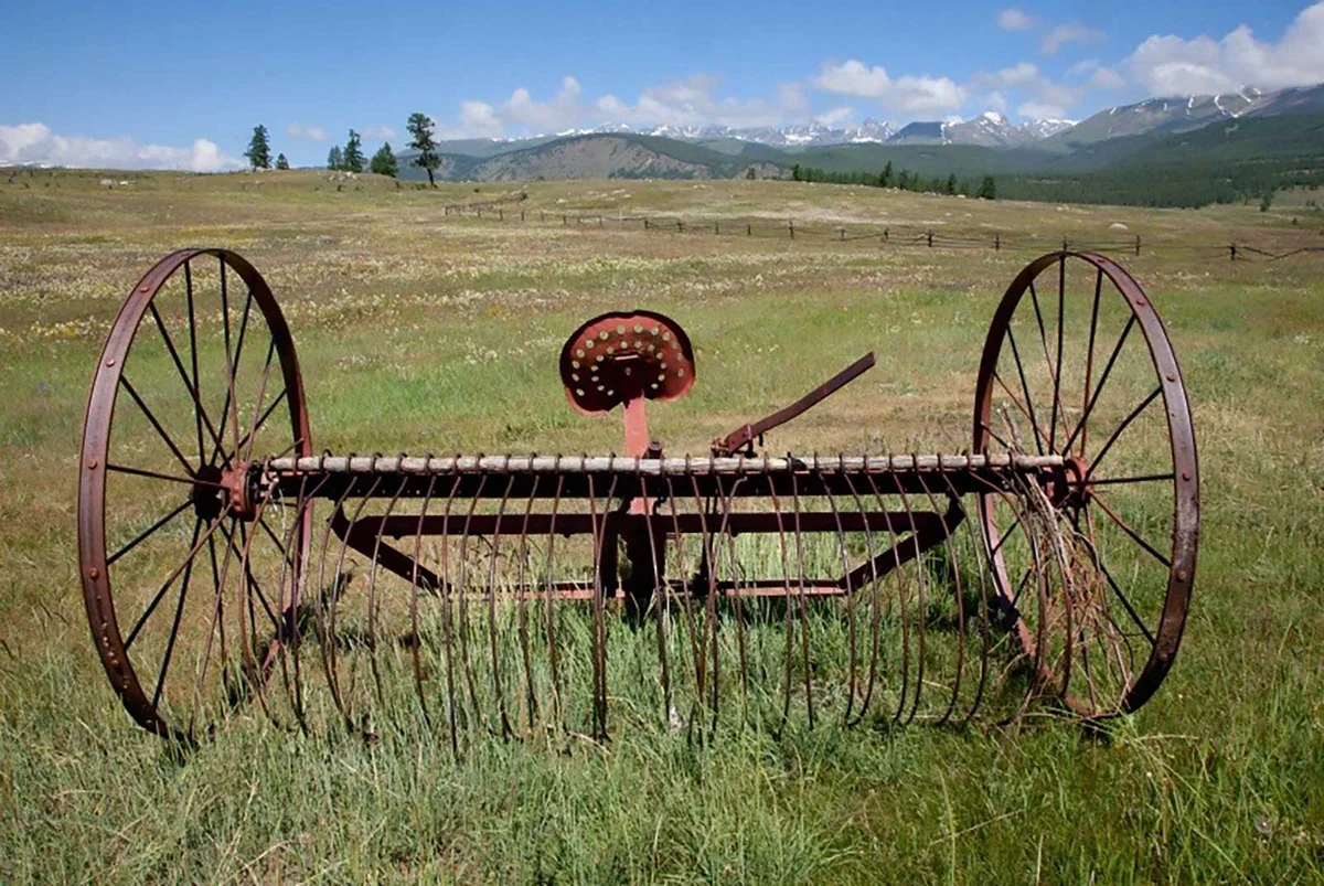 abandoned hay rake in field