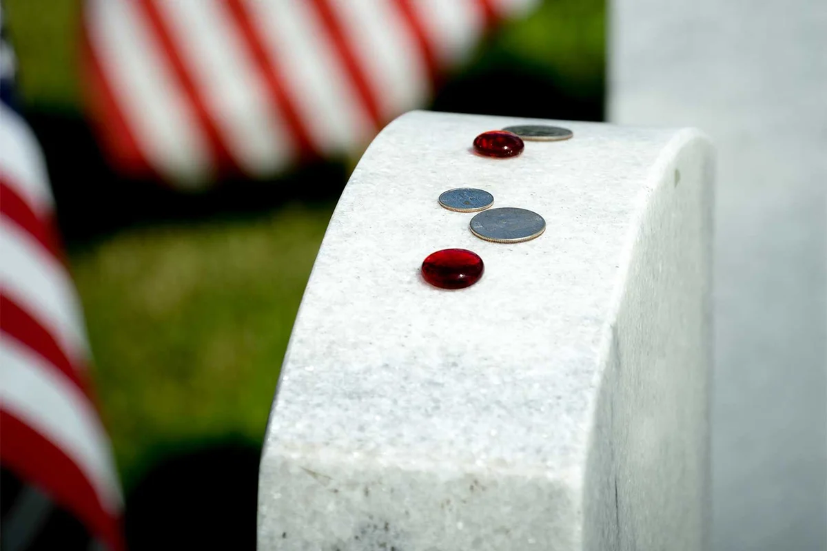 glass stone and coins on gravestone