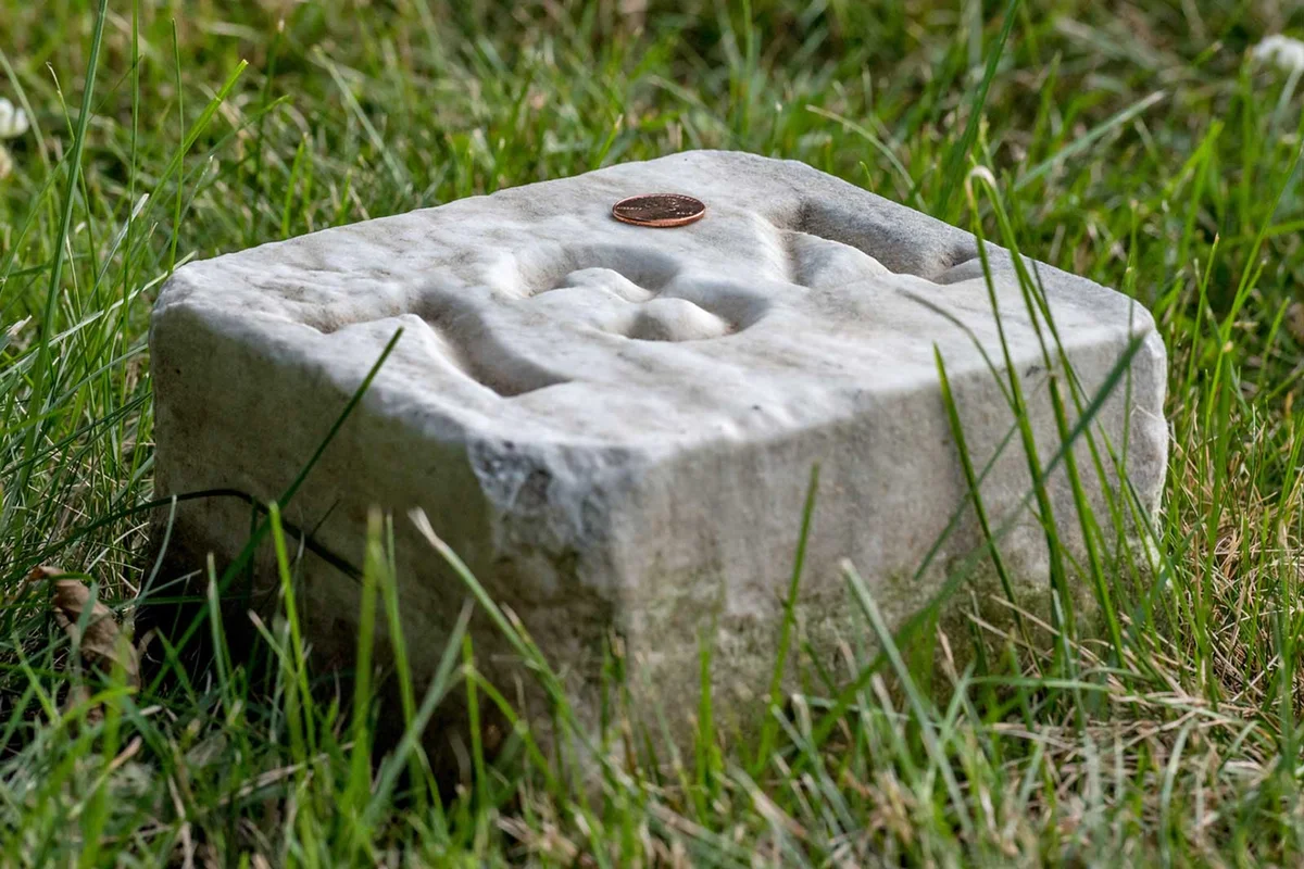 penny on grave marker of unknown soldier