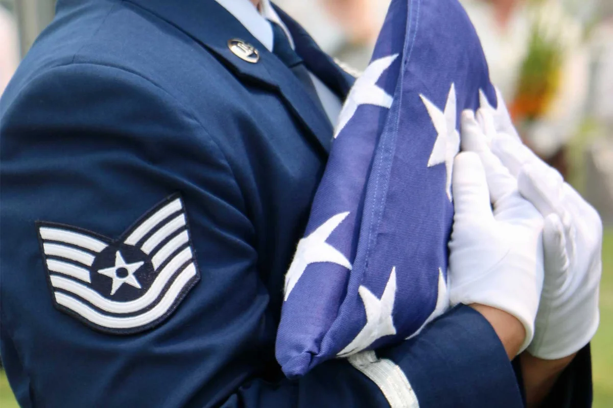 military funeral with soldier holding folded flag
