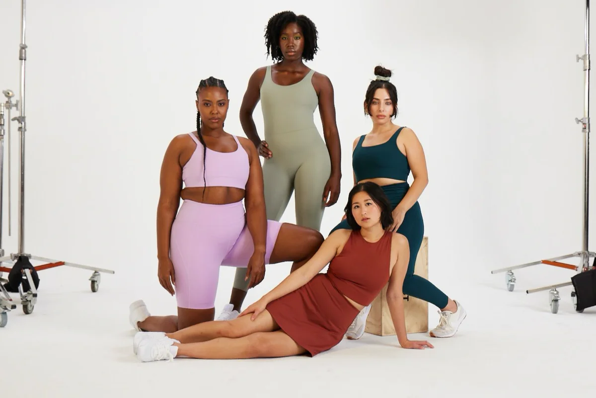 Four female models posed in Girlfriend Collective clothes.
