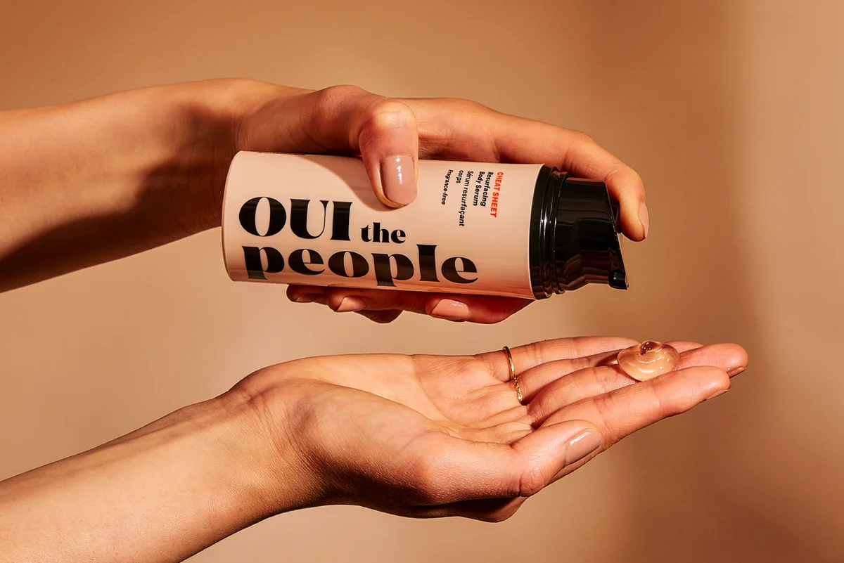 Photo of two hands using OUI the People's Cheat Sheet resurfacing body serum.