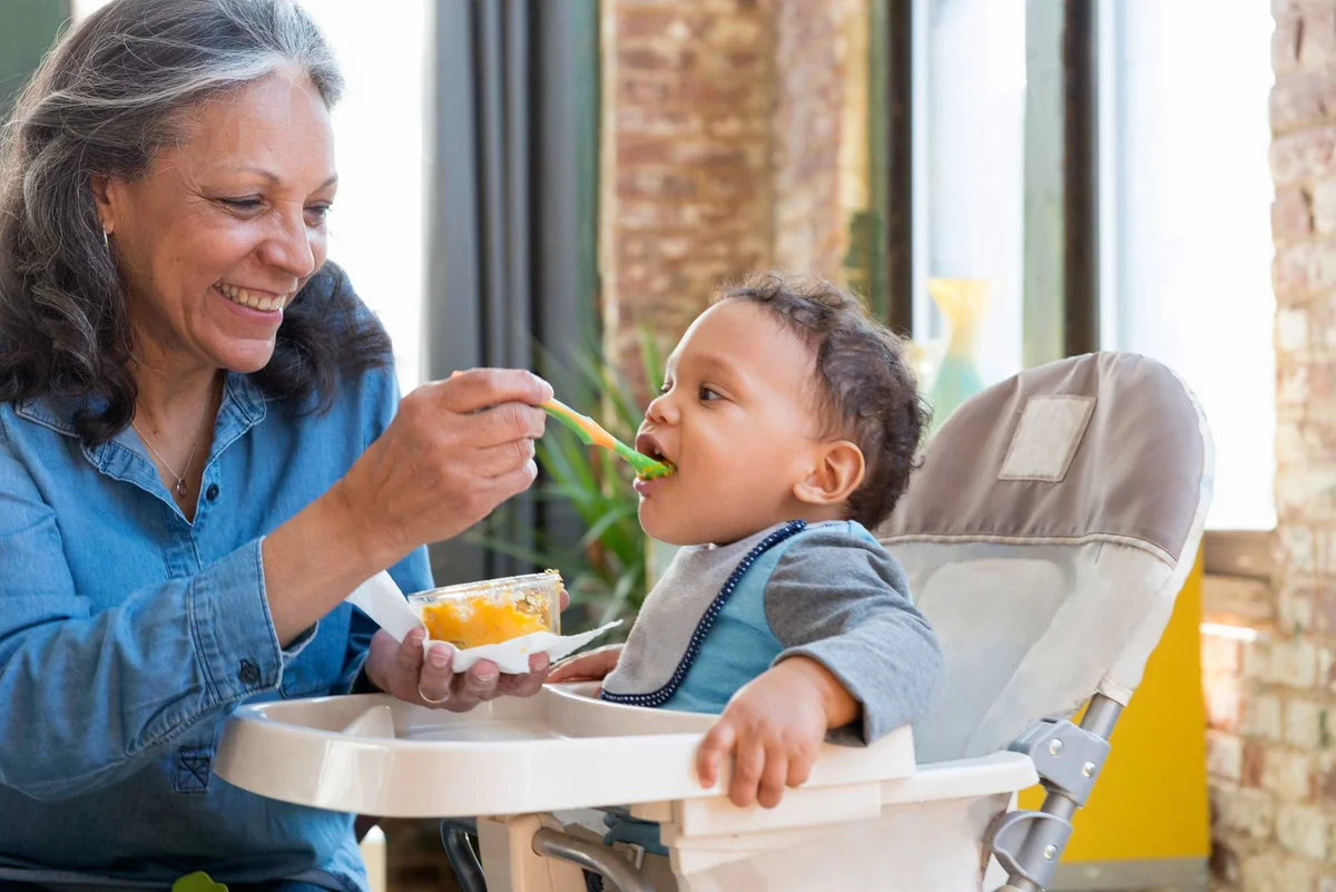 grandmother feeding grandson