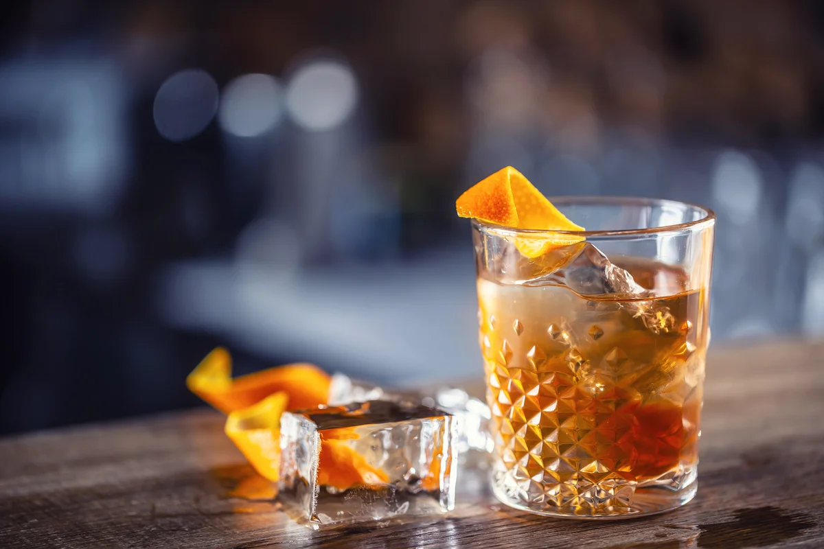 Old fashioned on ice with orange zest garnish