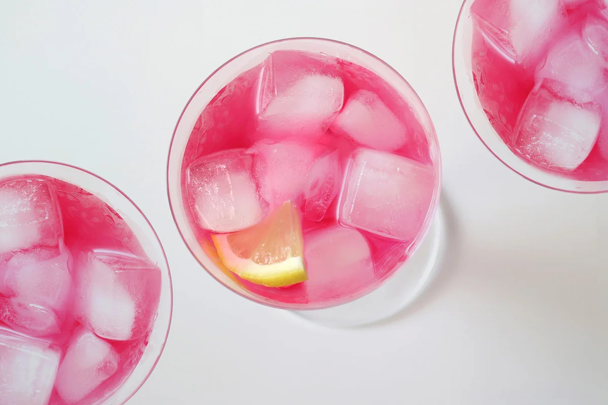 Glasses of cocktail 'Pink Flamingo' with icecubes and lemon slice