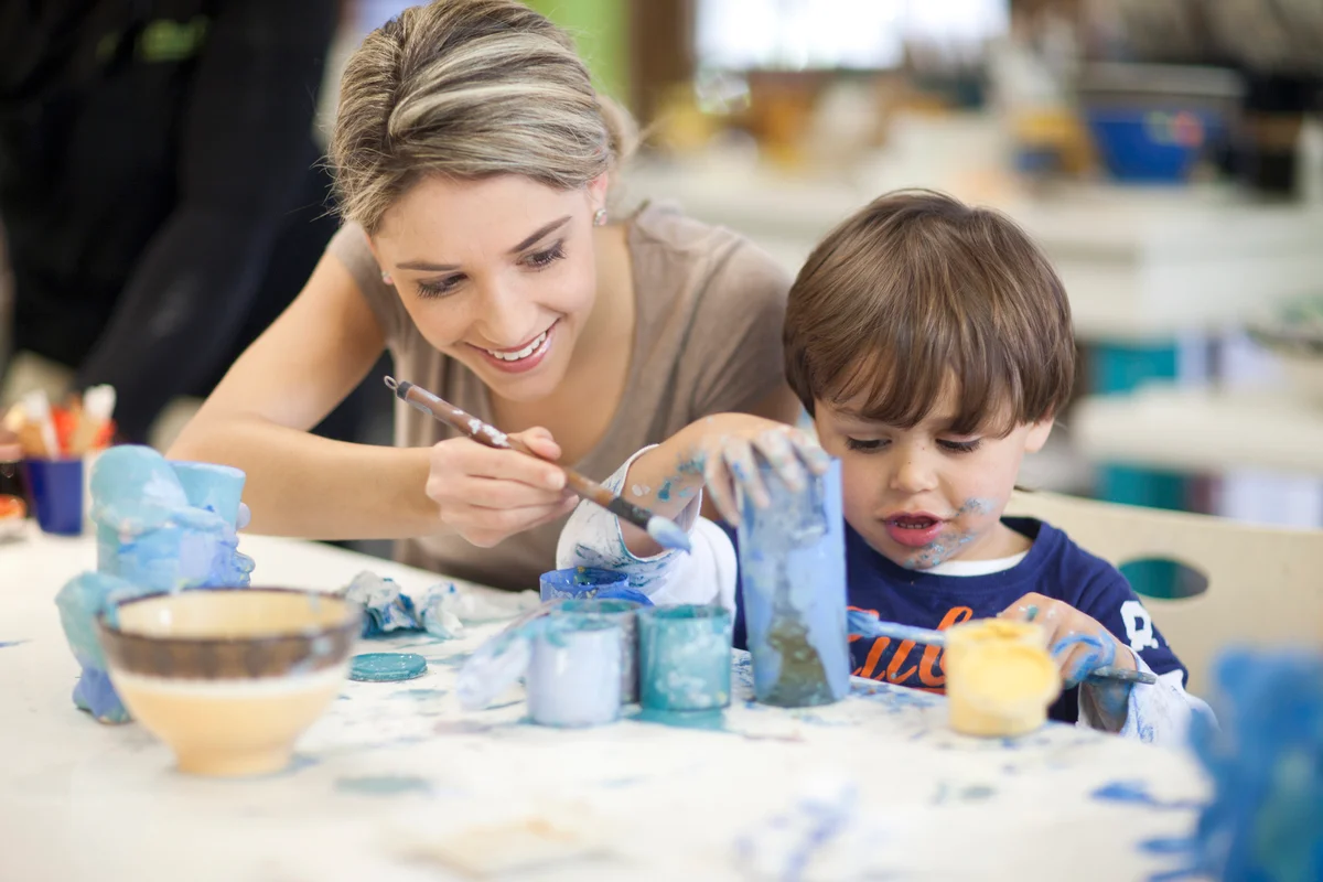 Toddler and mother painting pots