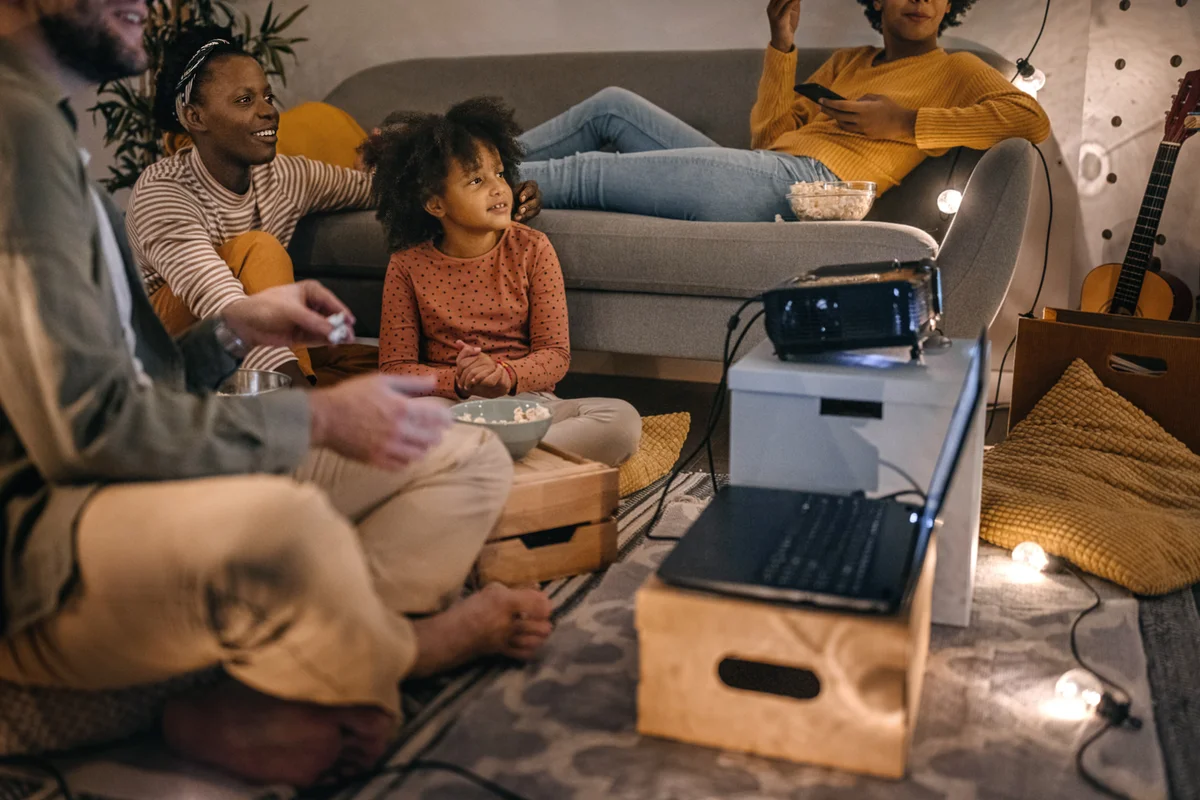Family sitting together watching movie on projector screen