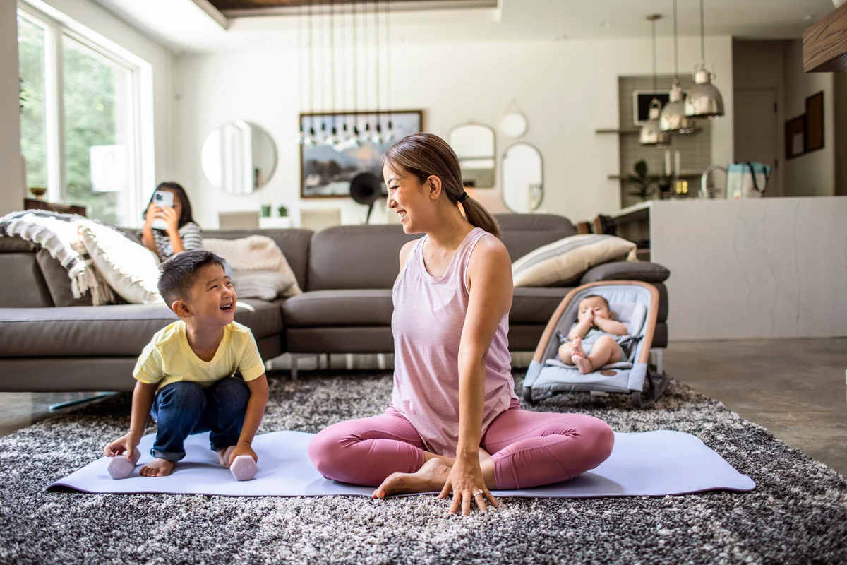 Mother doing yoga at home surrounded by children
