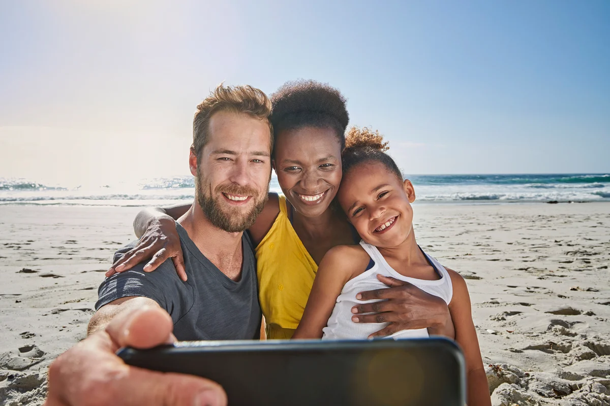 Family taking self portrait on beach