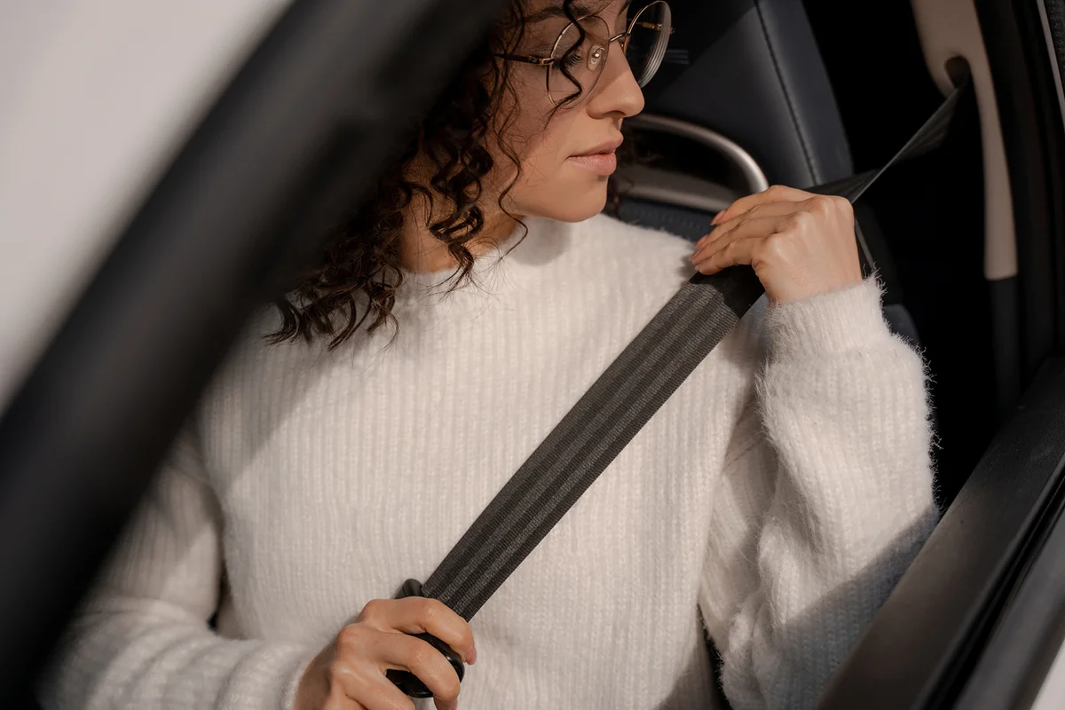 Woman buckles down seat belt in car
