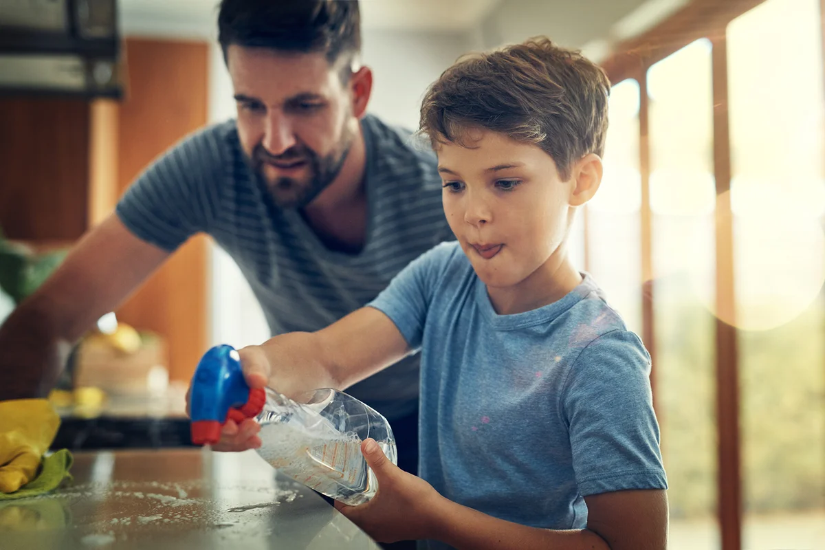 Father and son cleaning the kitchen counter together at home
