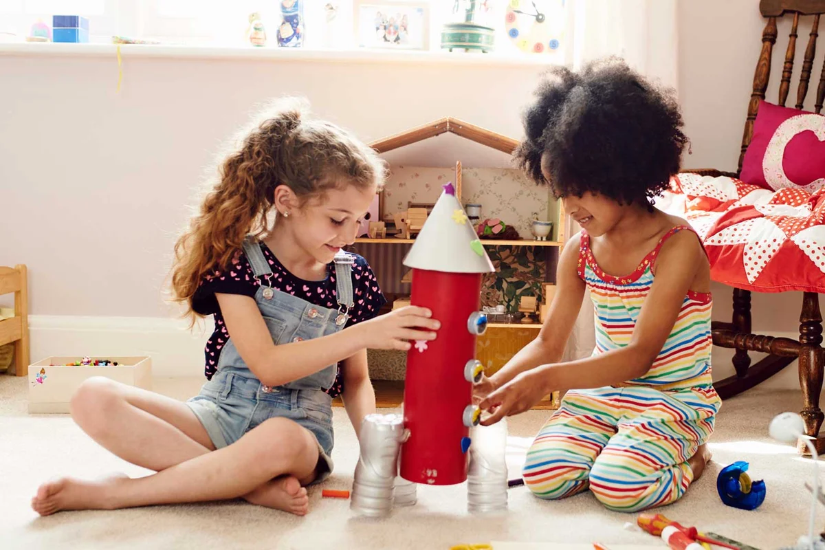 girls building toy rocket ship