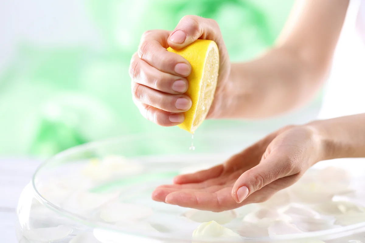 Woman squeezing lemon juice in her hand