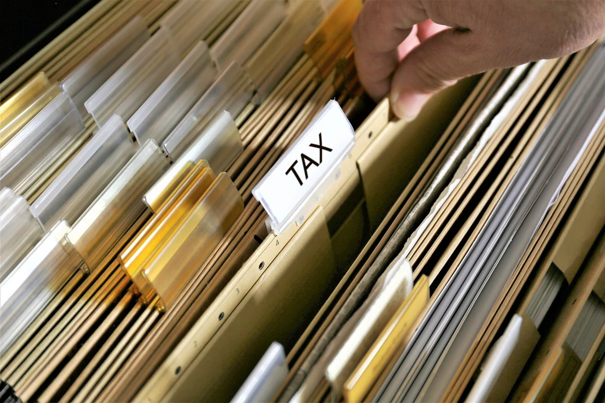Hand Of Man Picking Up Document In Filing Cabinet