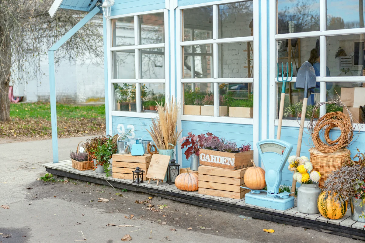 Garden tools arranged on the porch in front of a small floral shop