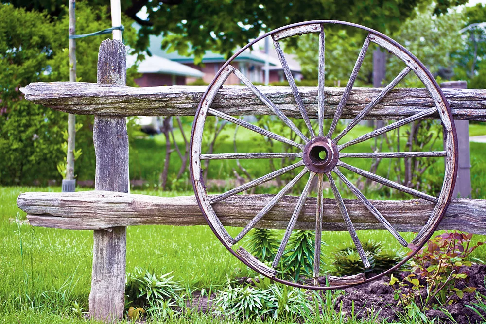 Decorative vintage wooden wheel hanging on the fence