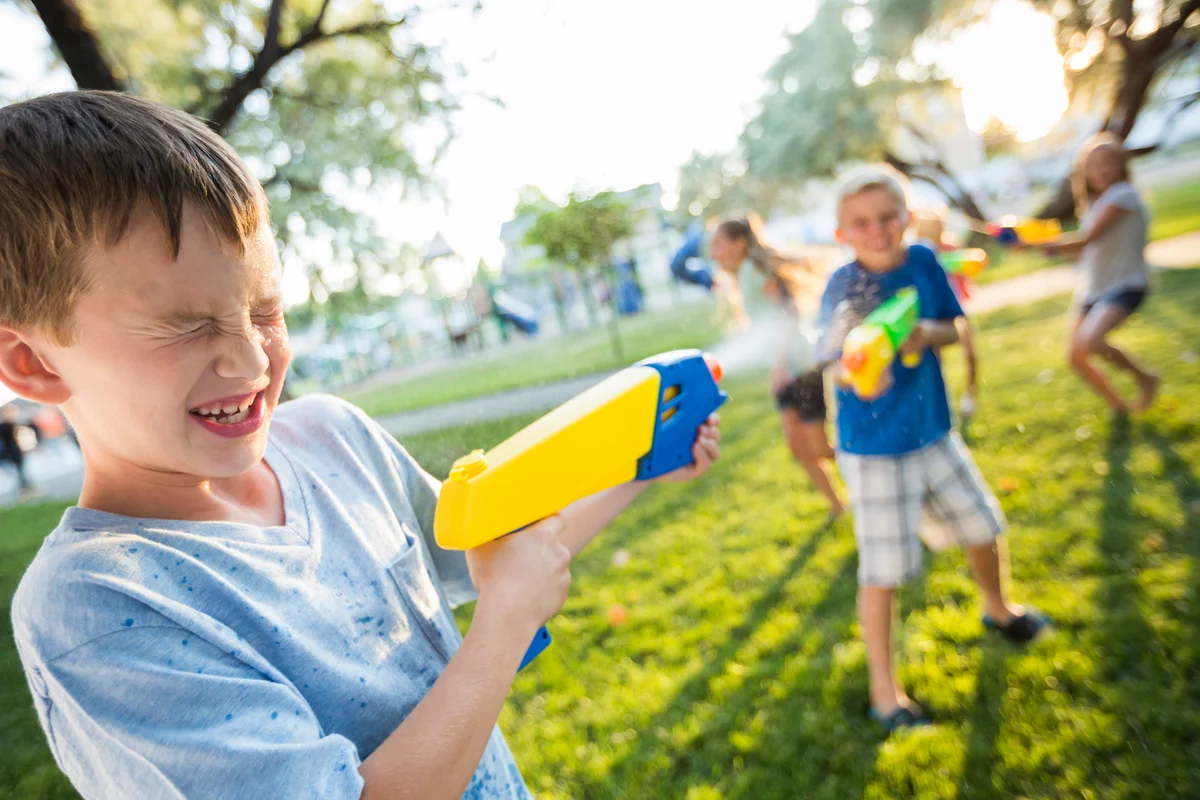 Boys and girls playing with squirt guns