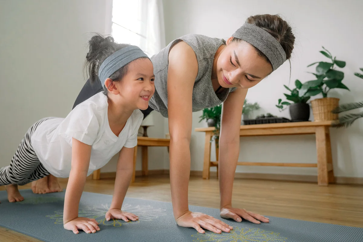 Mother and daughter doing yoga at home