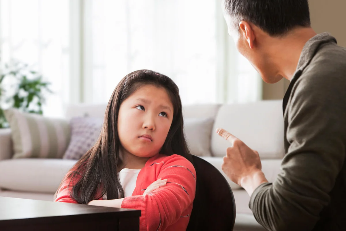 Father scolding pouting daughter