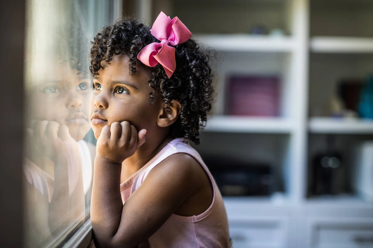 Portrait of preschool age girl looking out window