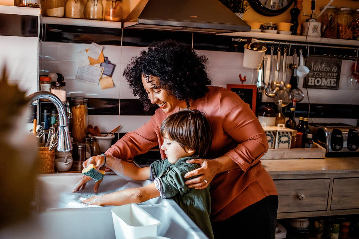 Mother and son washing dishes