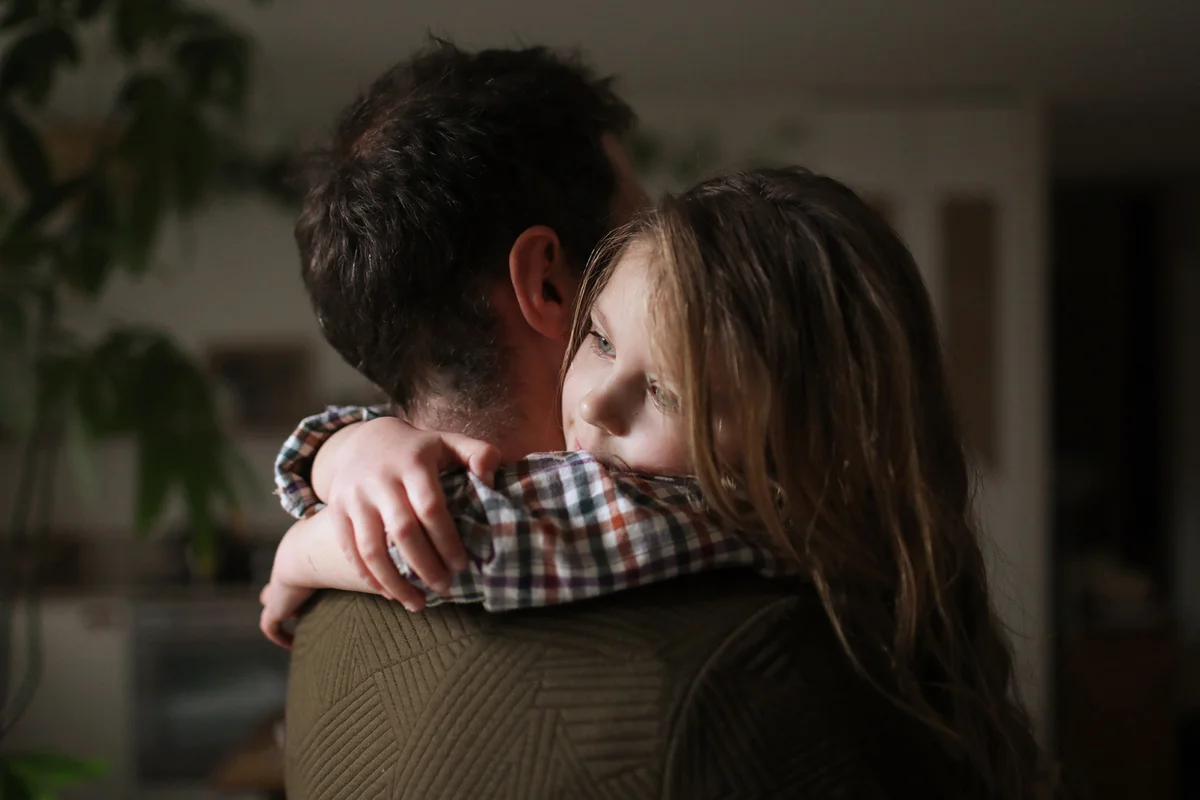 A father and his daughter cuddling at home