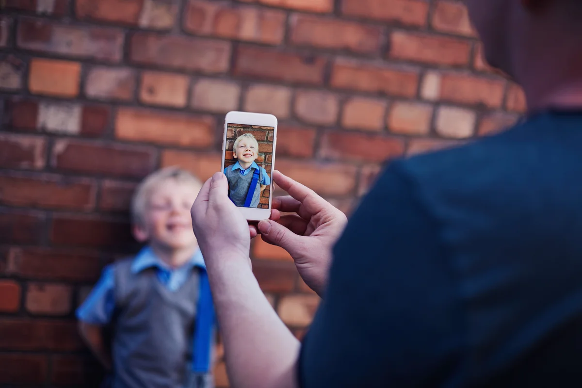 boy getting picture taken on first day of school