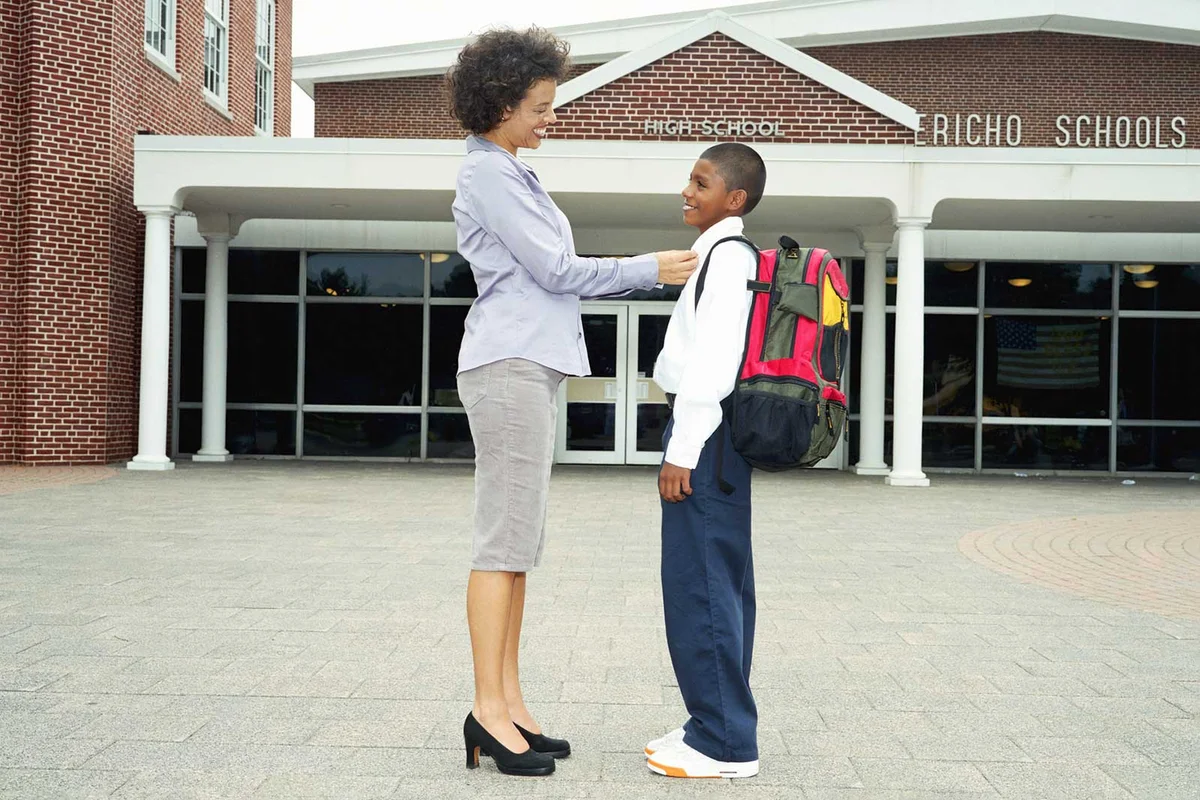 mother and son in front of school on first day
