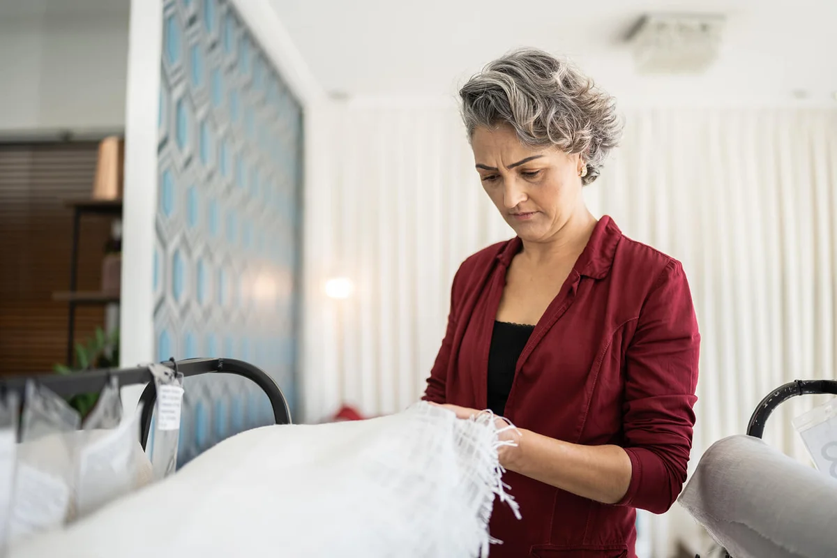woman looking at a fabric piece at a furniture store