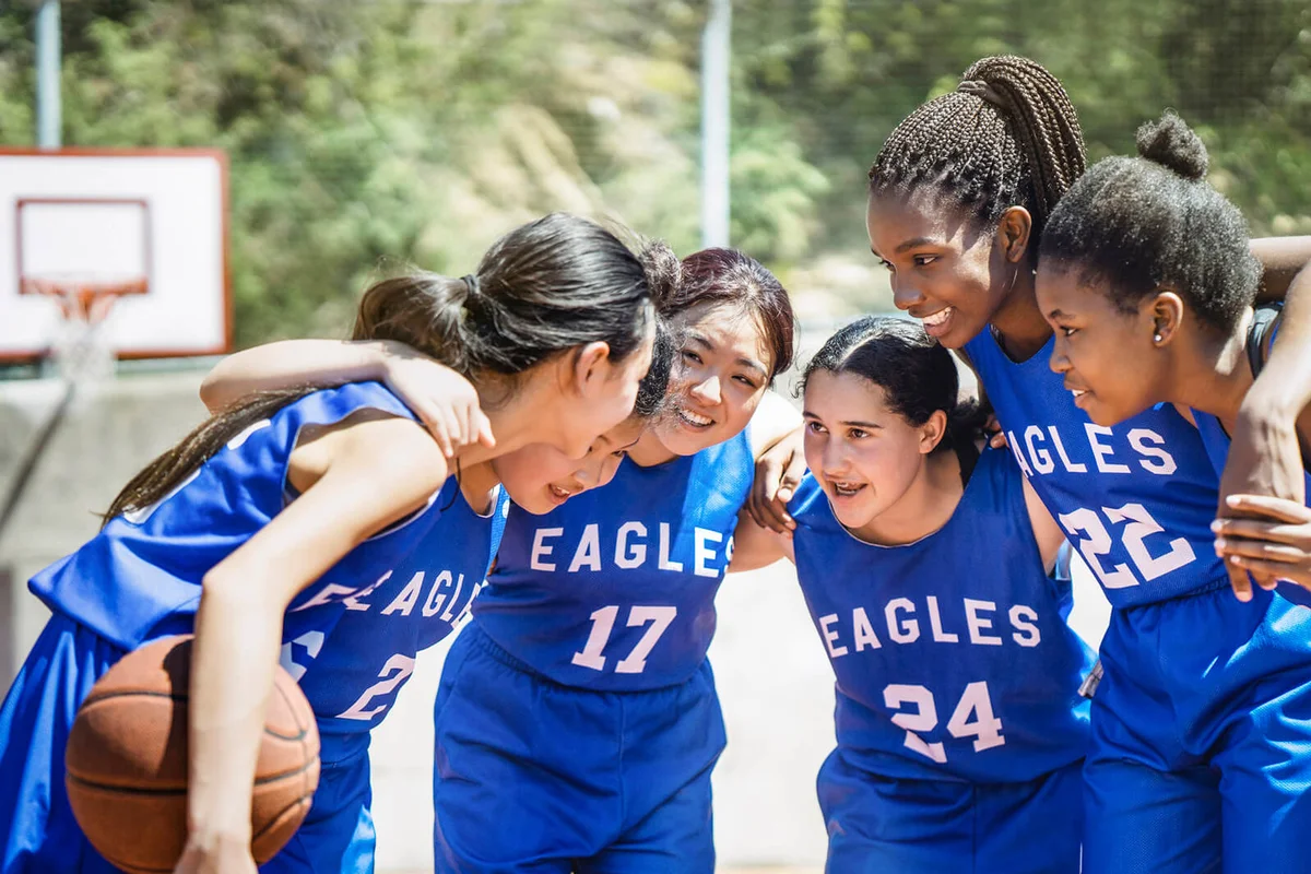 Female basketball players huddling on court