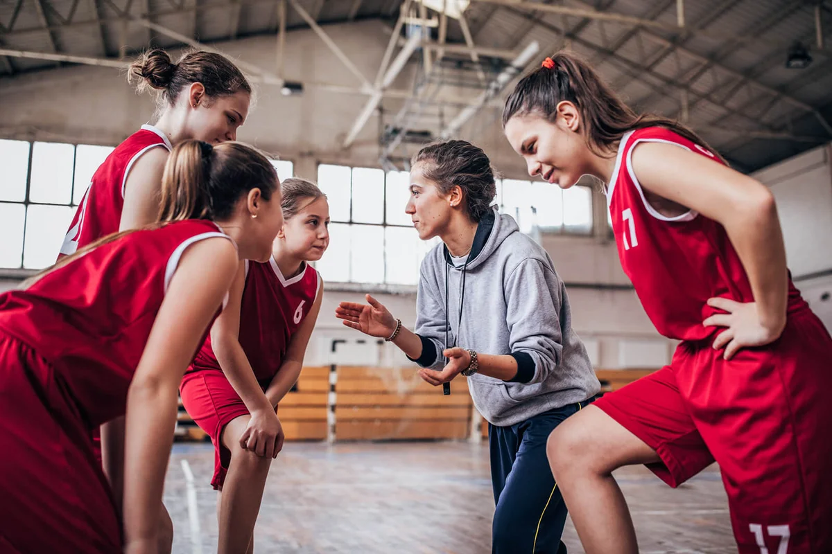 Coach standing with basketball team