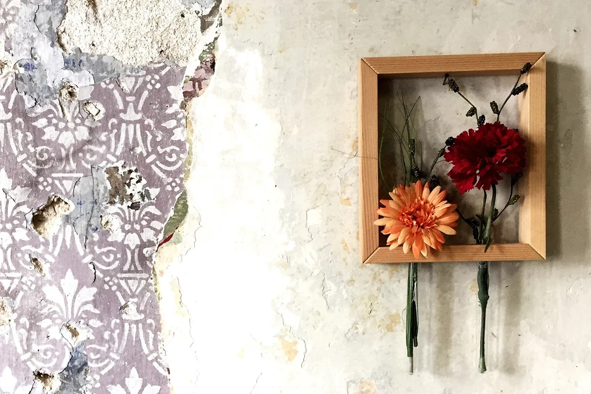 Flowers In Frame On Damaged Wall