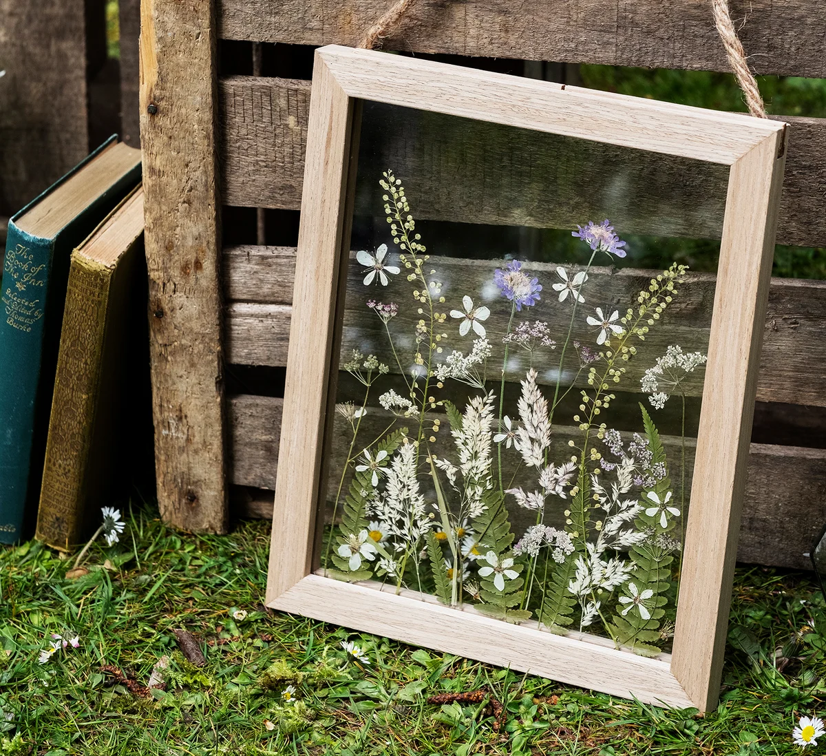 Close up of floral arrangement in wooden frame, decorations for a naming ceremony in a forest