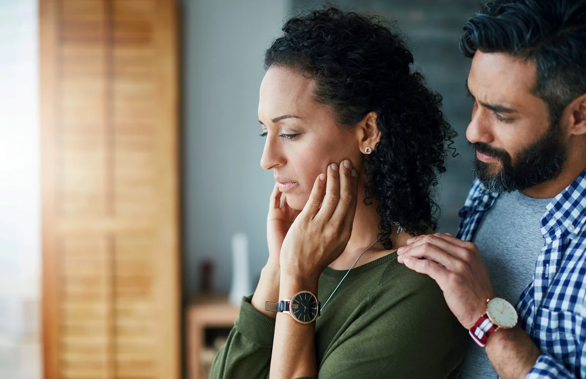 Man comforting his distraught wife at home