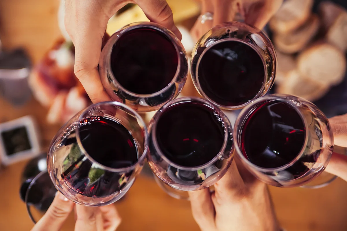 Friends clinking red wine glasses