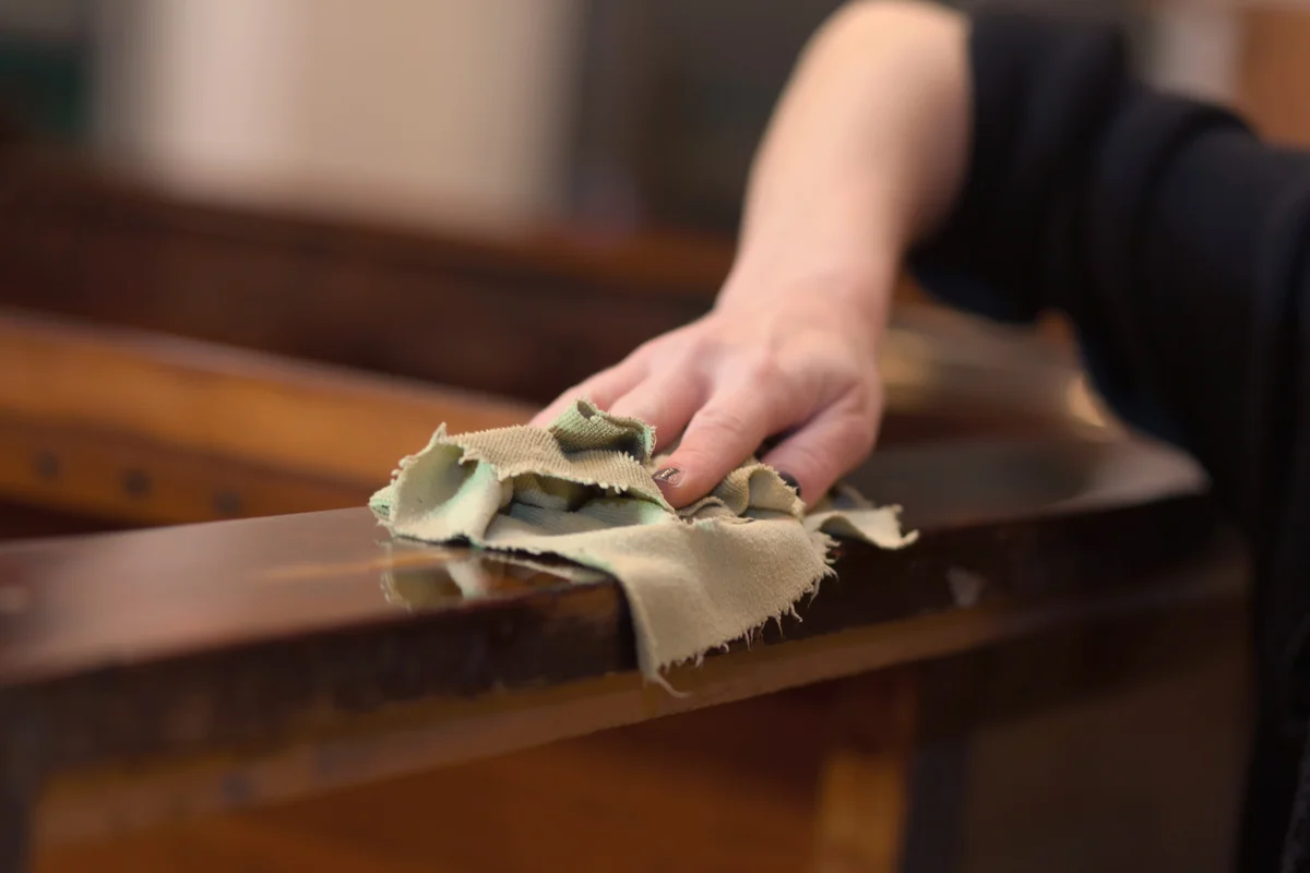 Woman cleaning wood furniture