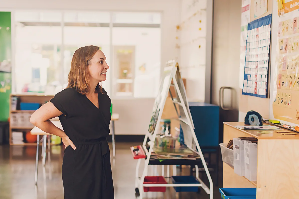 Female teacher looking at alphabet board in her classroom