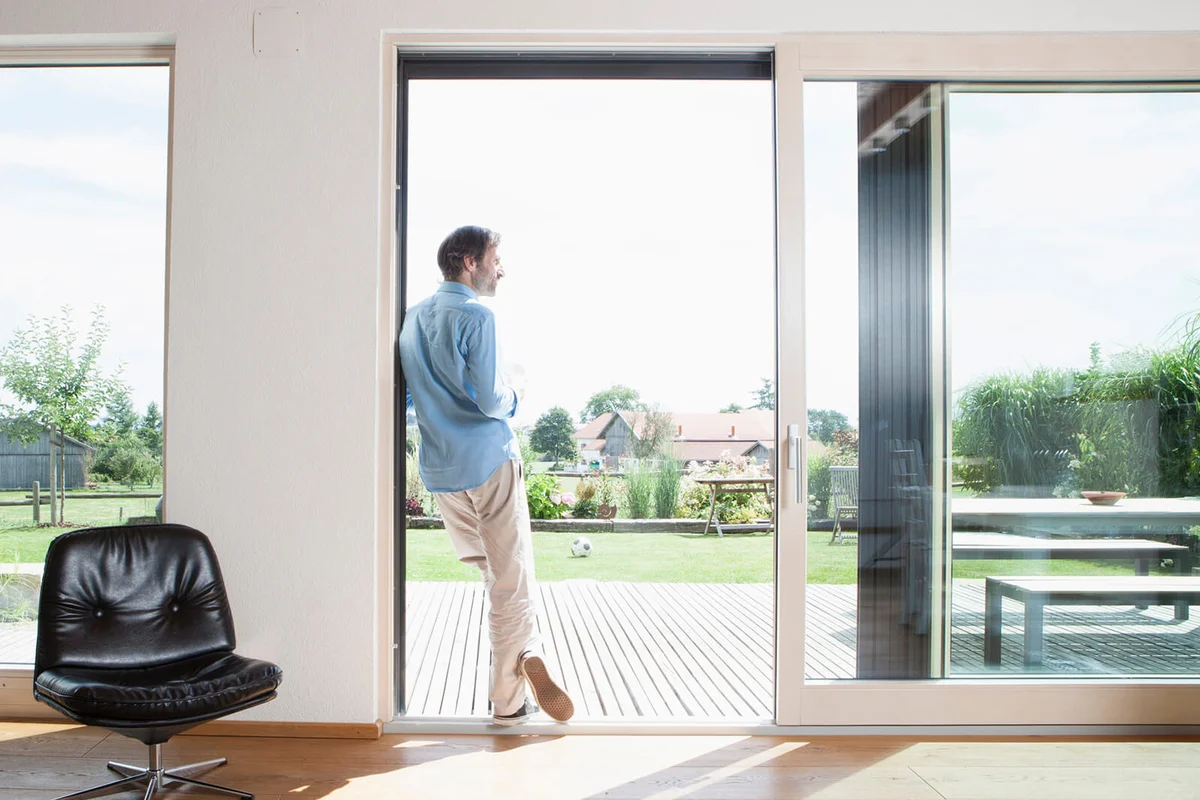 Mature man leaning in garden door
