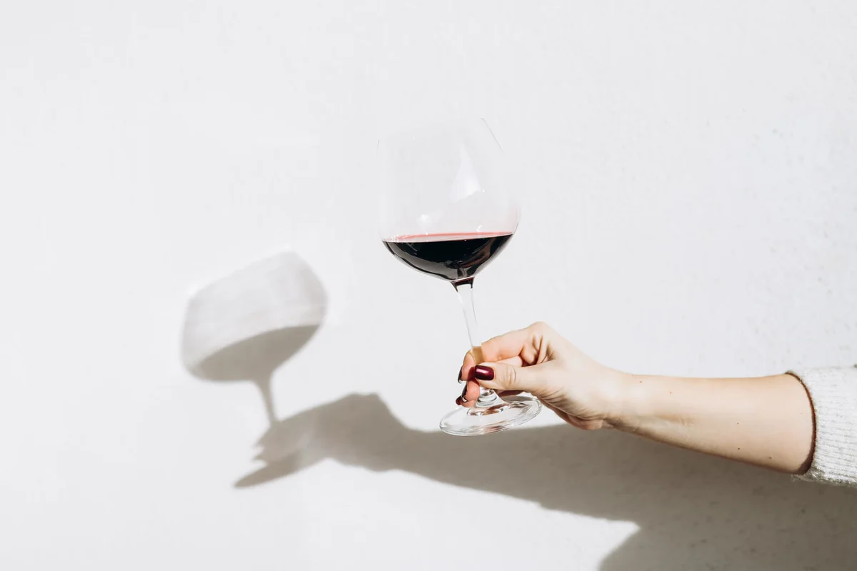 Women's hand holding a glass of red wine