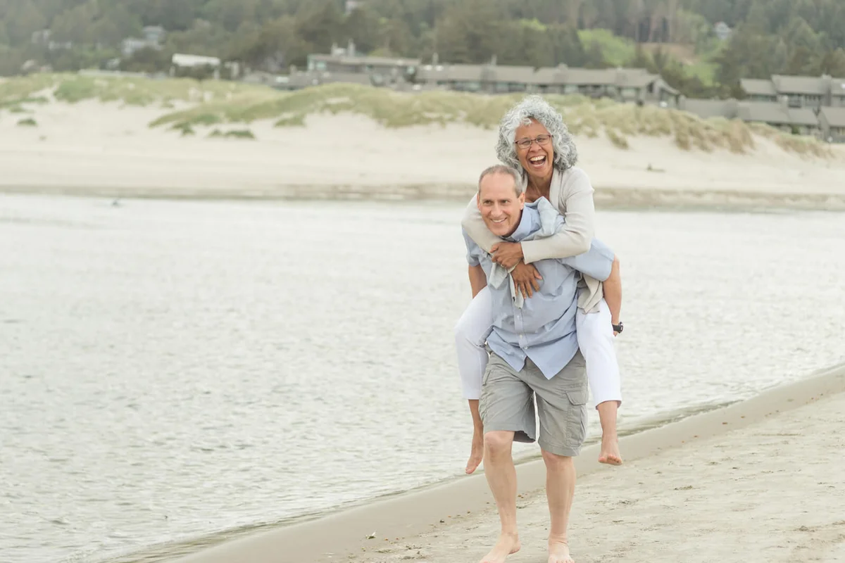 A cute mature couple enjoy each other's company as they walk along the Oregon beach