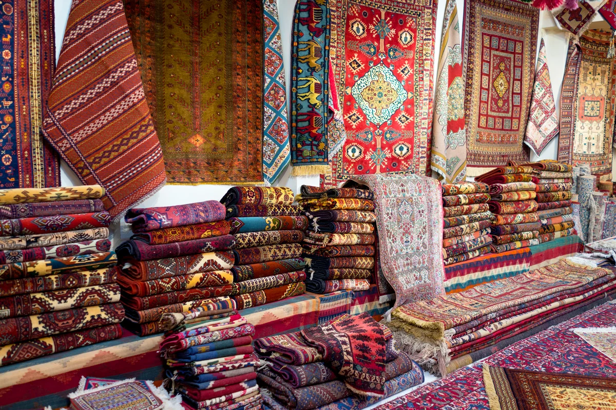 Large stacks of oriental Persian rugs in a store