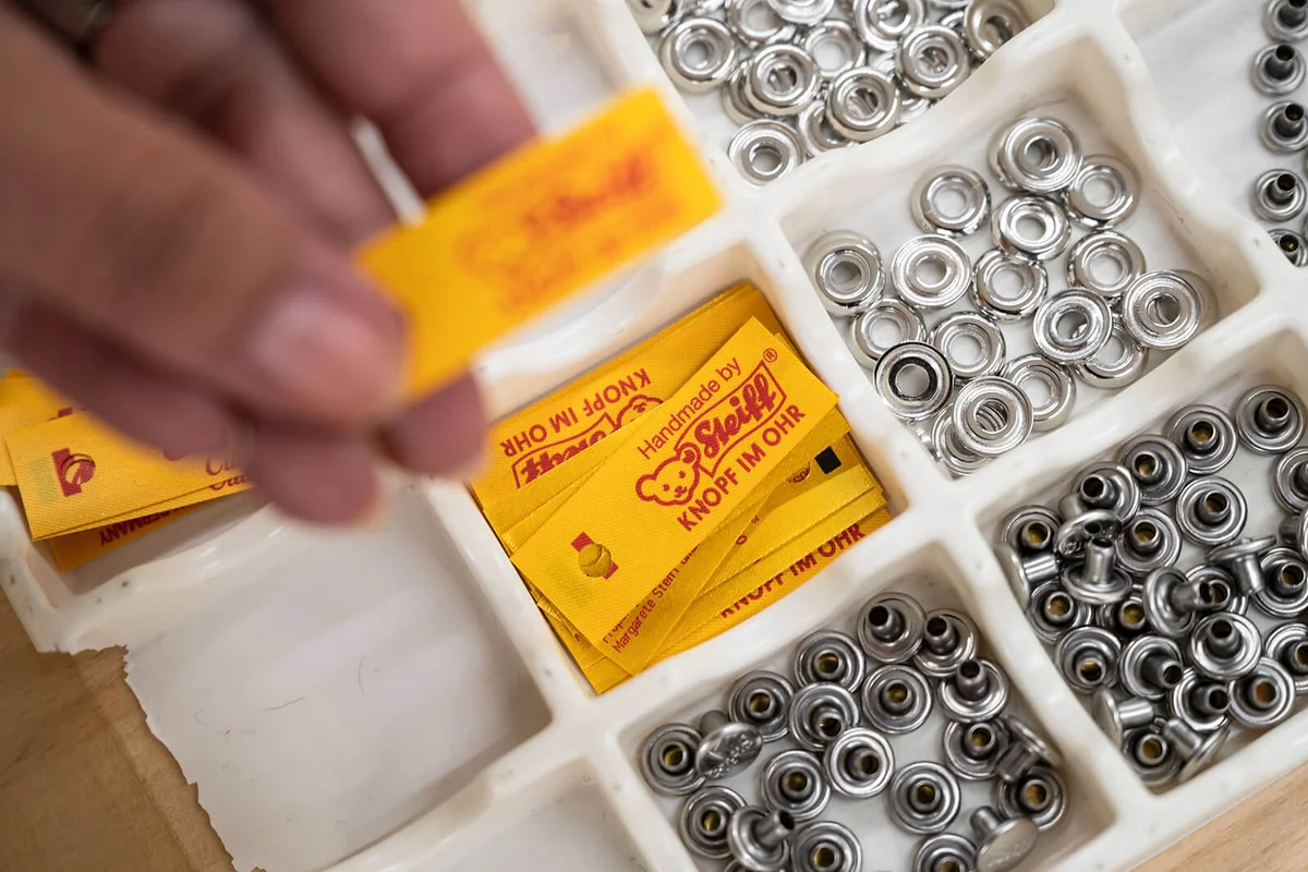 An employee in production at Margarete Steiff GmbH takes a flag for a "button in the ear" | Getty Editorial Use