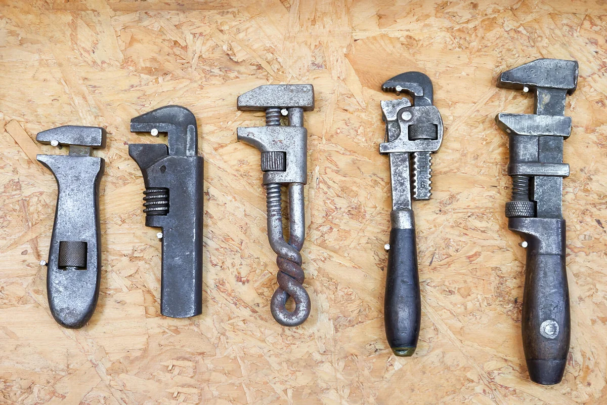 close up many different old tools hanging on wall