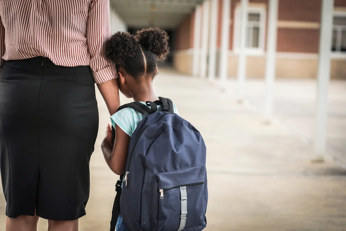 girl with mom on first day of school.