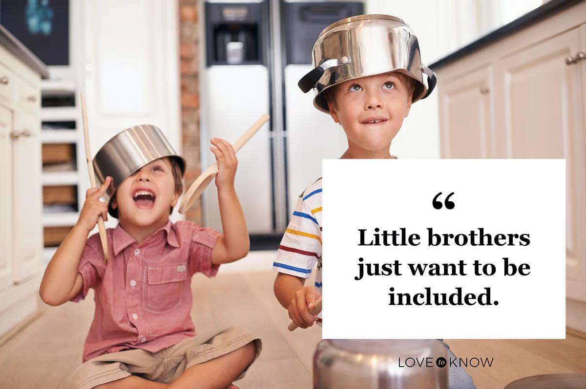 Two young boys sitting on the kitchen floor playing with pots and pans