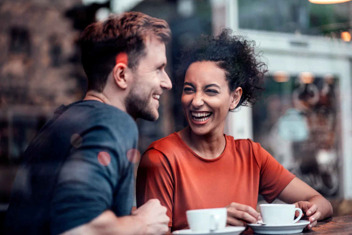 Happy couple having coffee while sitting at cafe
