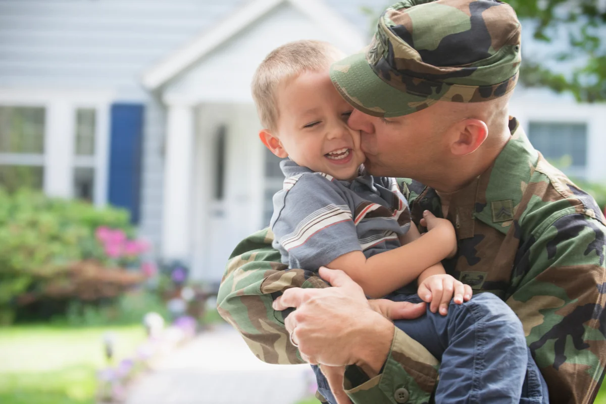 military father kissing son
