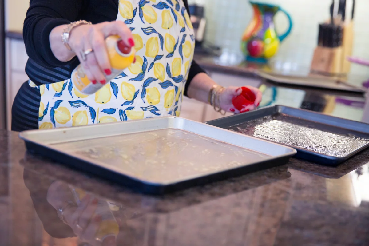 Senior woman greasing baking sheets