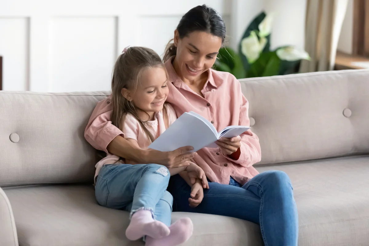 Woman reading book to little kid