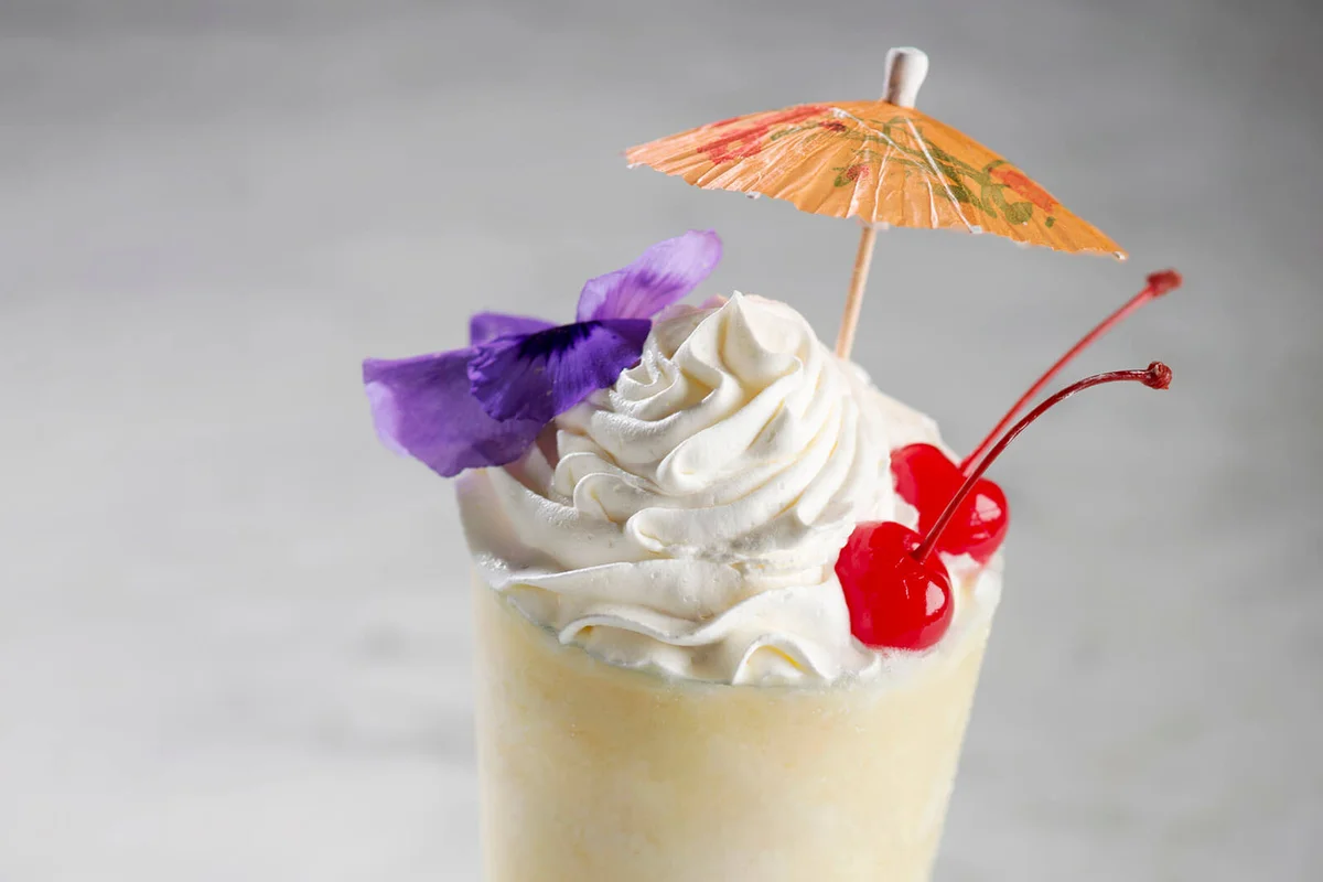tall cocktail, with umbrella, & cherry garnish